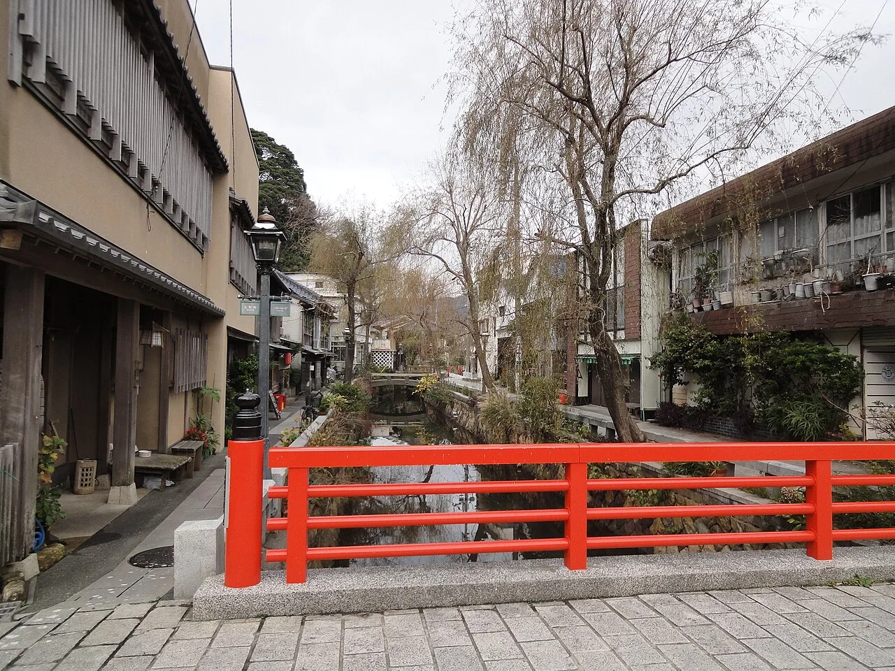 Red bridge over the canal and traditional buildings along Perry Road in Shimoda